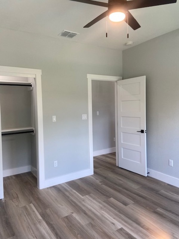 116 Field Street Luling, TX 78648 - Photo 32 of 33 A well-lit bedroom features sturdy laminate flooring and an open closet, ready for personalization.