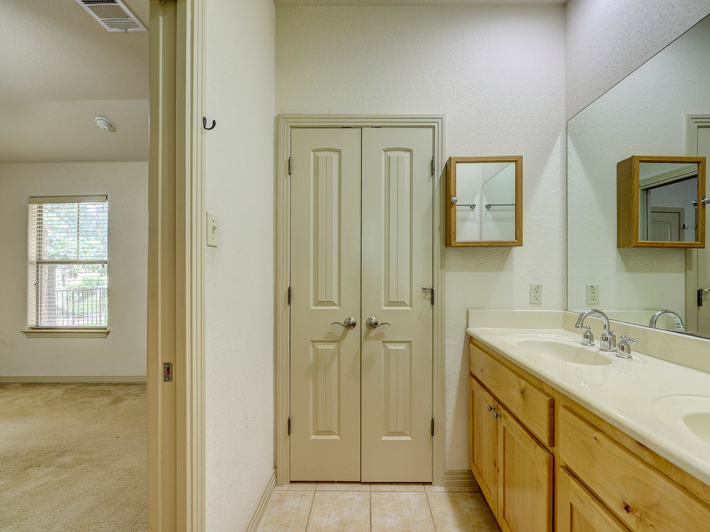 9707 Anderson Mill Road, Unit 22 Austin, TX 78750 - Photo 34 of 39 Double vanities and ample storage define this practical bathroom space.