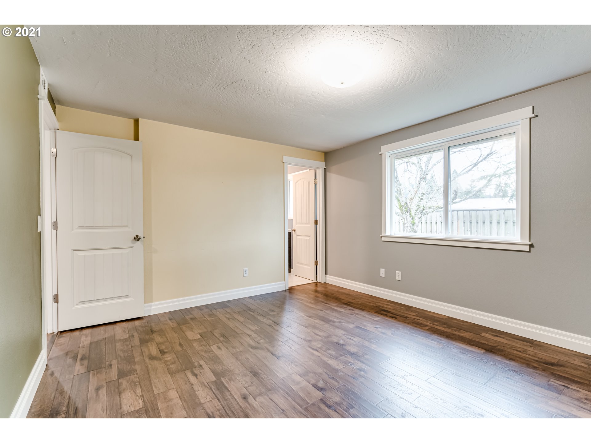 5609 C Street Springfield, OR 97478 - Photo 13 of 26 a view of an empty room with wooden floor and a window
