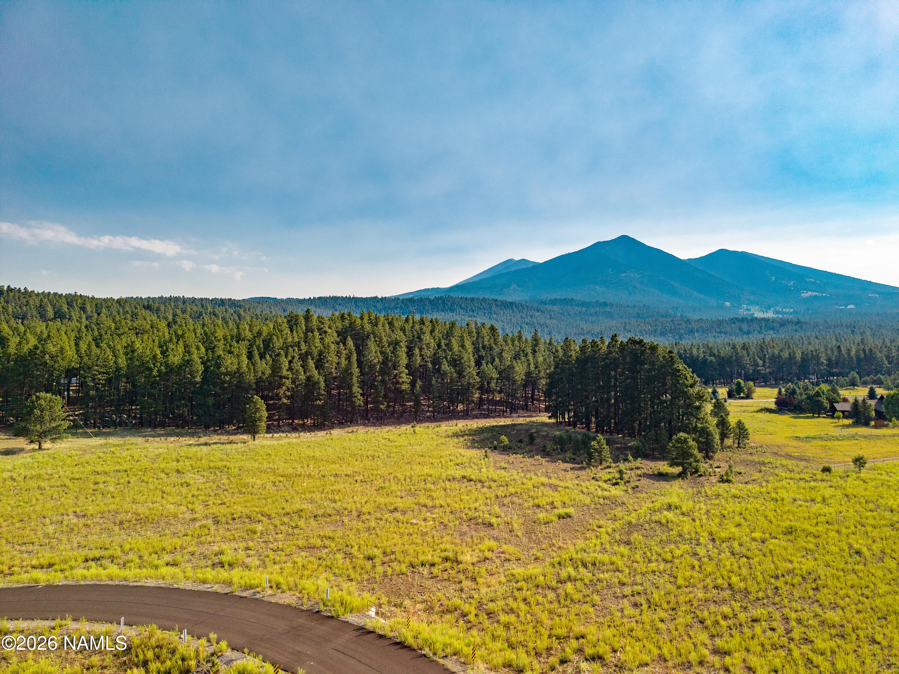 9217 Ranch At The Peaks Way Flagstaff, AZ 86001 - Photo 1 of 12 a view of a swimming pool with a yard and a large tree