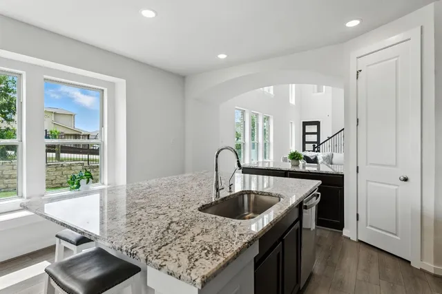 a kitchen with stainless steel appliances granite countertop a sink stove and refrigerator
