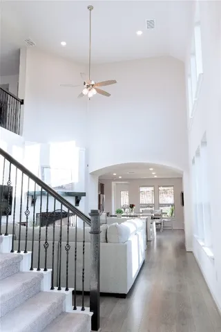 a living room with furniture kitchen view and a chandelier