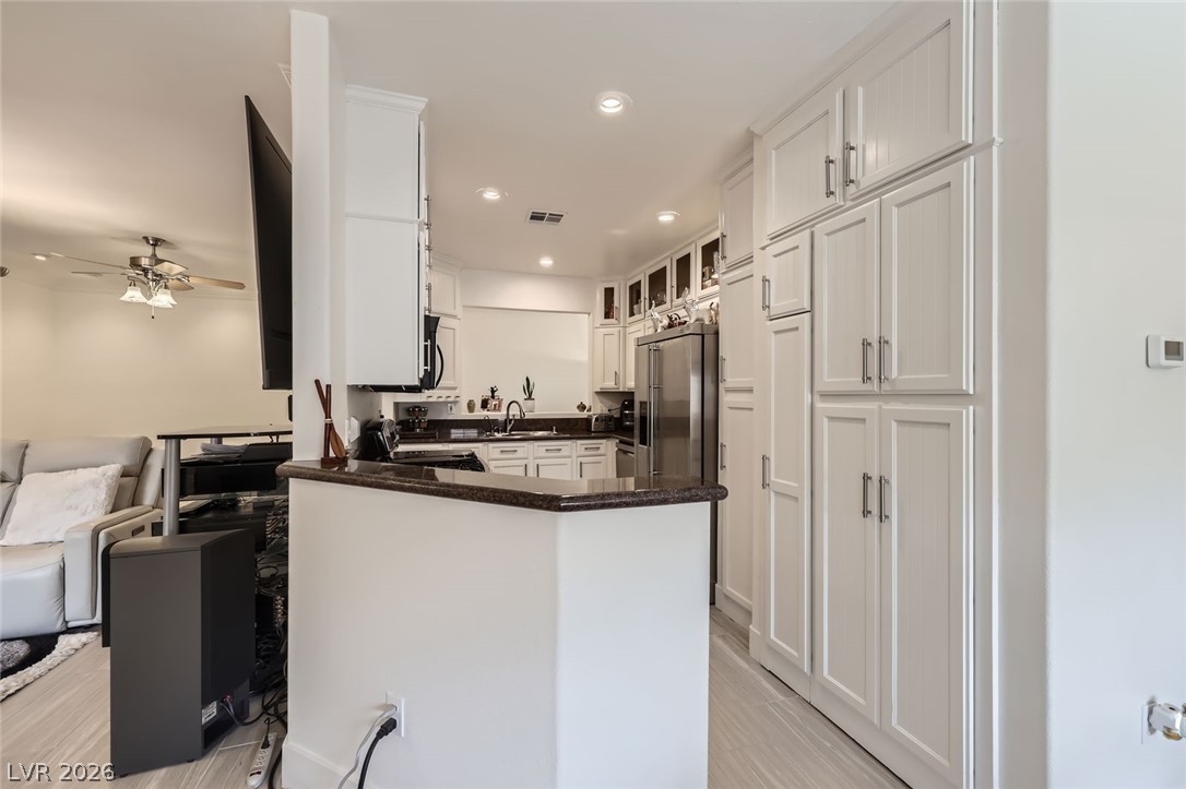 2050 West Warm Springs Road, Unit 3624 Henderson, NV 89014 - Photo 39 of 40 Kitchen with open floor plan, white cabinets, a peninsula, ceiling fan, and recessed lighting