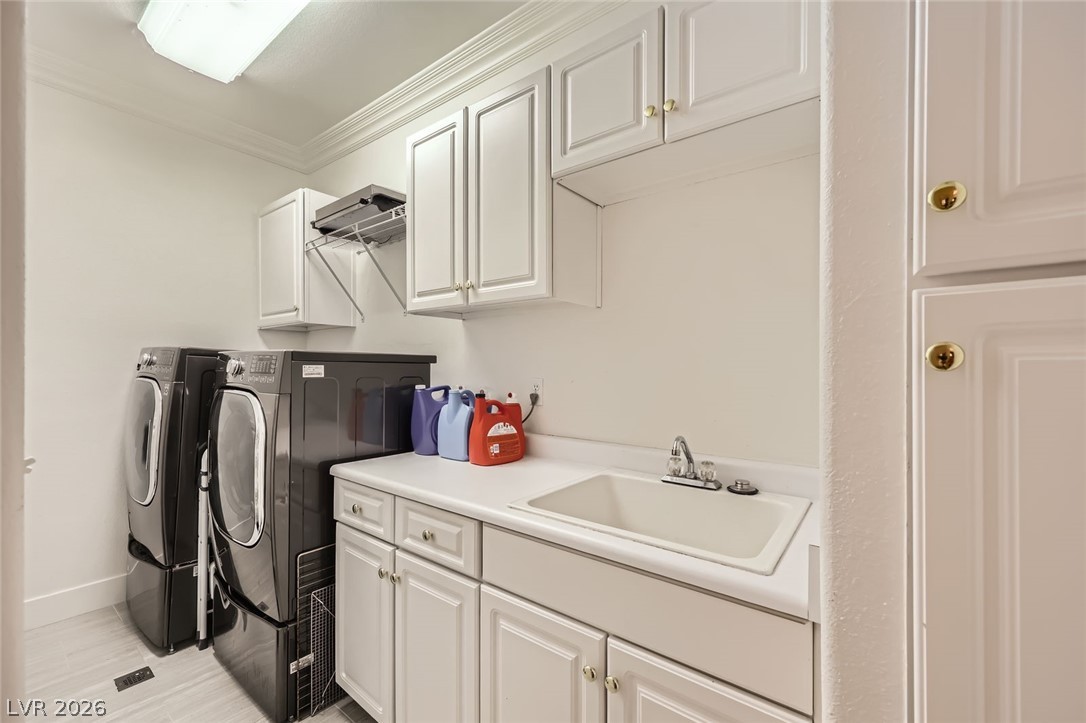 2050 West Warm Springs Road, Unit 3624 Henderson, NV 89014 - Photo 30 of 40 Laundry area featuring washer and clothes dryer, cabinet space, and crown molding