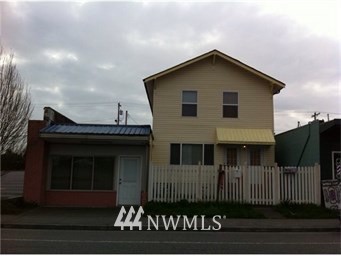 a view of a house with a small yard and wooden fence