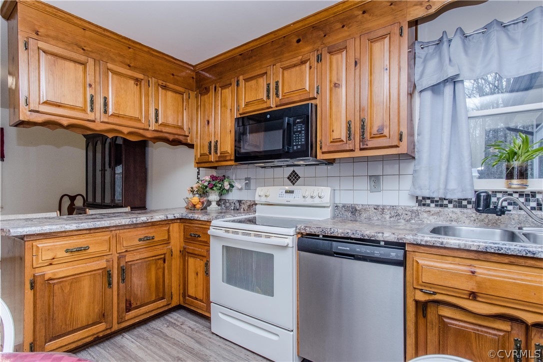 15890 Templeton Road Disputanta, VA 23842 - Photo 23 of 44 Beautiful all wood cabinetry, with updated countertops, new flooring, tile backsplash. Window above the sink, overlooking the large deck.
