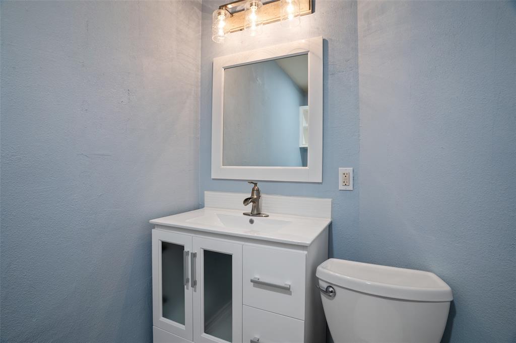 1204 Morrow Lane Allen, TX 75002 - Photo 18 of 19 a bathroom with a toilet sink and mirror