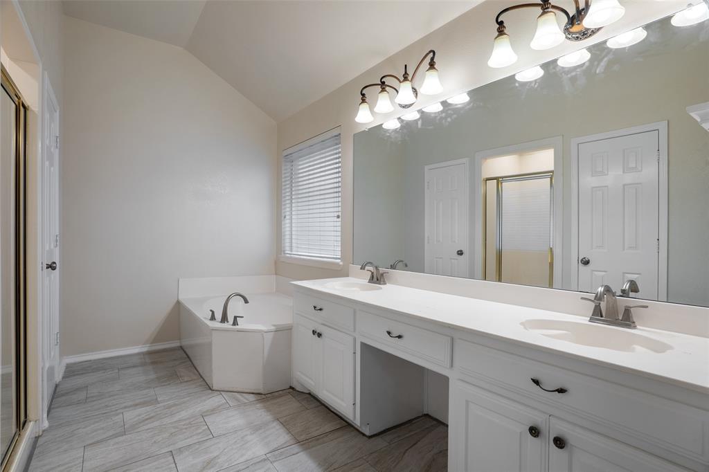 1204 Morrow Lane Allen, TX 75002 - Photo 8 of 19 a spacious bathroom with a granite countertop sink a large mirror and bathtub