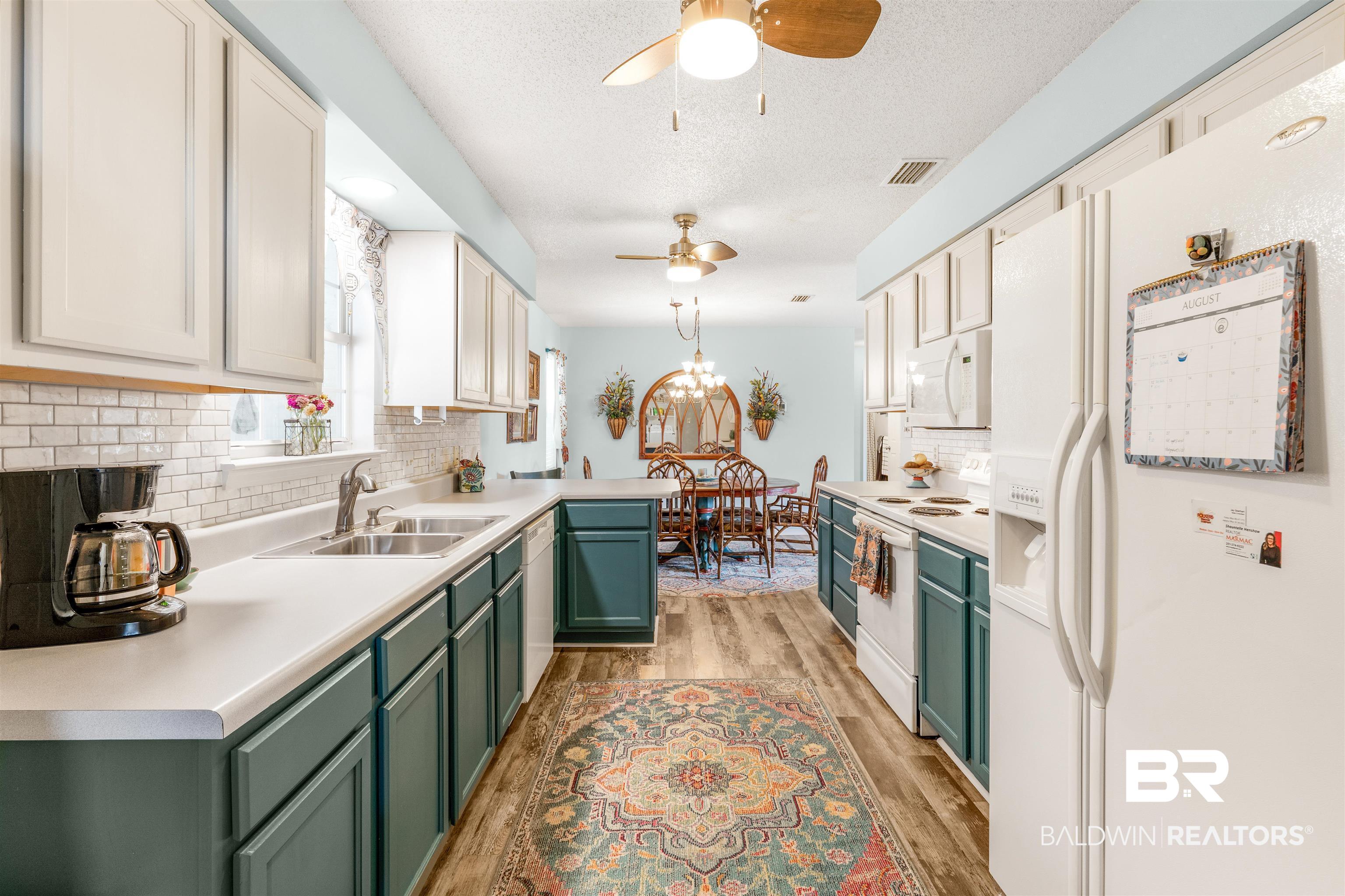 518 Ariel Avenue Foley, AL 36535 - Photo 13 of 47 Kitchen with white appliances, green cabinets, sink, ceiling fan, and light wood-type flooring