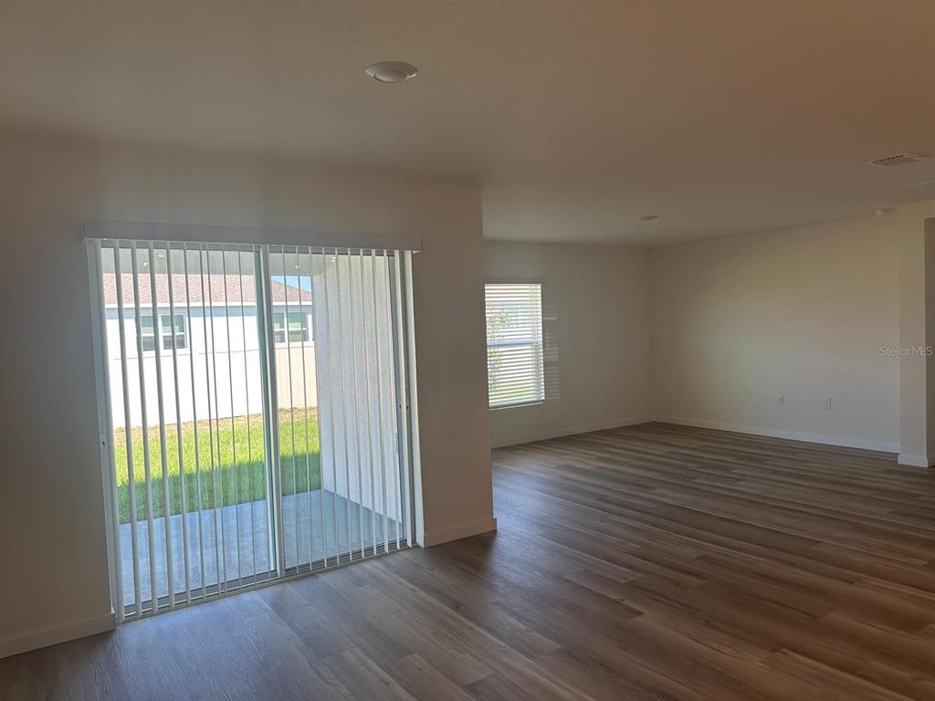 4697 Southwest 89th Street Ocala, FL 34476 - Photo 9 of 11 an empty room with wooden floor and windows