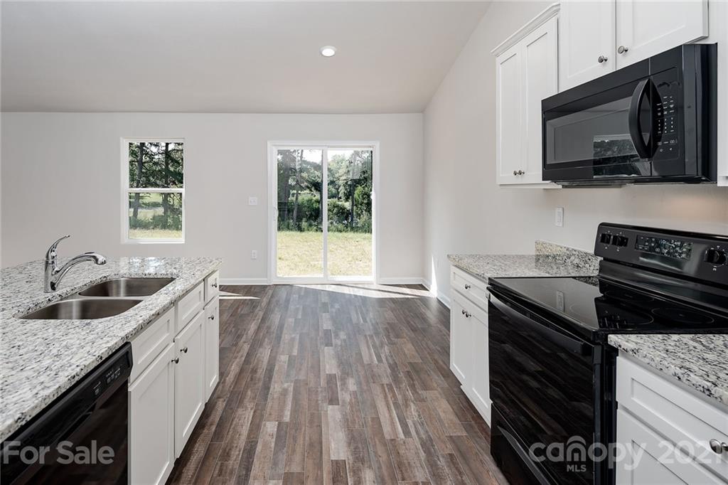 226 Caley Street Kings Mountain, NC 28086 - Photo 5 of 12 a kitchen with granite countertop a sink wooden floor and stainless steel appliances