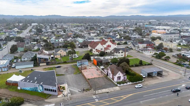 an aerial view of residential houses with outdoor space and parking