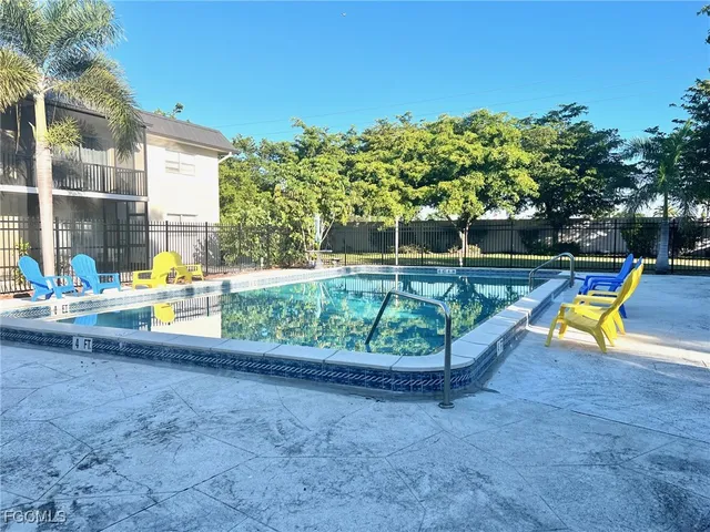 a view of a swimming pool with a yard and sitting area