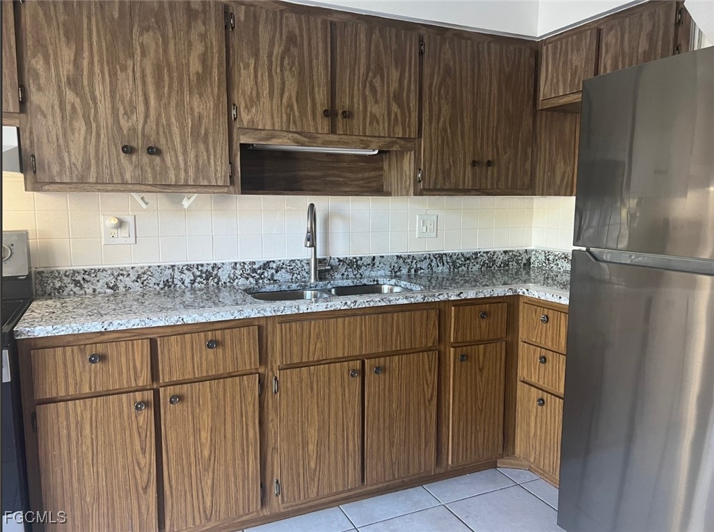 1560 Colonial Boulevard, Unit 134 Fort Myers, FL 33907 - Photo 9 of 12 a kitchen with granite countertop wood cabinets and stainless steel appliances