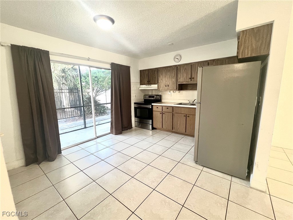 1560 Colonial Boulevard, Unit 134 Fort Myers, FL 33907 - Photo 10 of 12 a kitchen with stainless steel appliances granite countertop a refrigerator and a sink