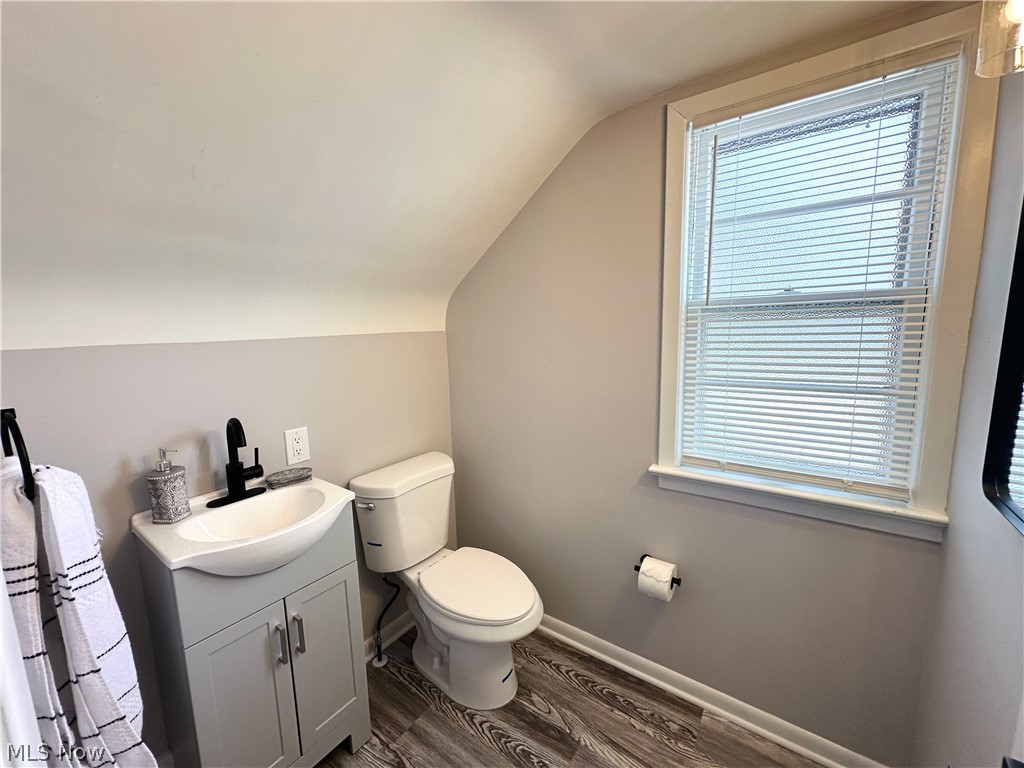 2440 Dentzler Road Parma, OH 44134 - Photo 9 of 11 Half bath with vanity, dark wood-style flooring, and lofted ceiling
