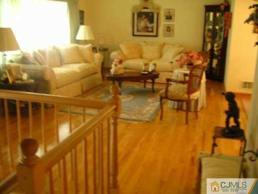 47 Wilk Road Edison, NJ 08837 - Photo 3 of 8 a living room with couches and kitchen view with wooden floor