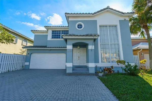 a front view of a house with a garden and plants