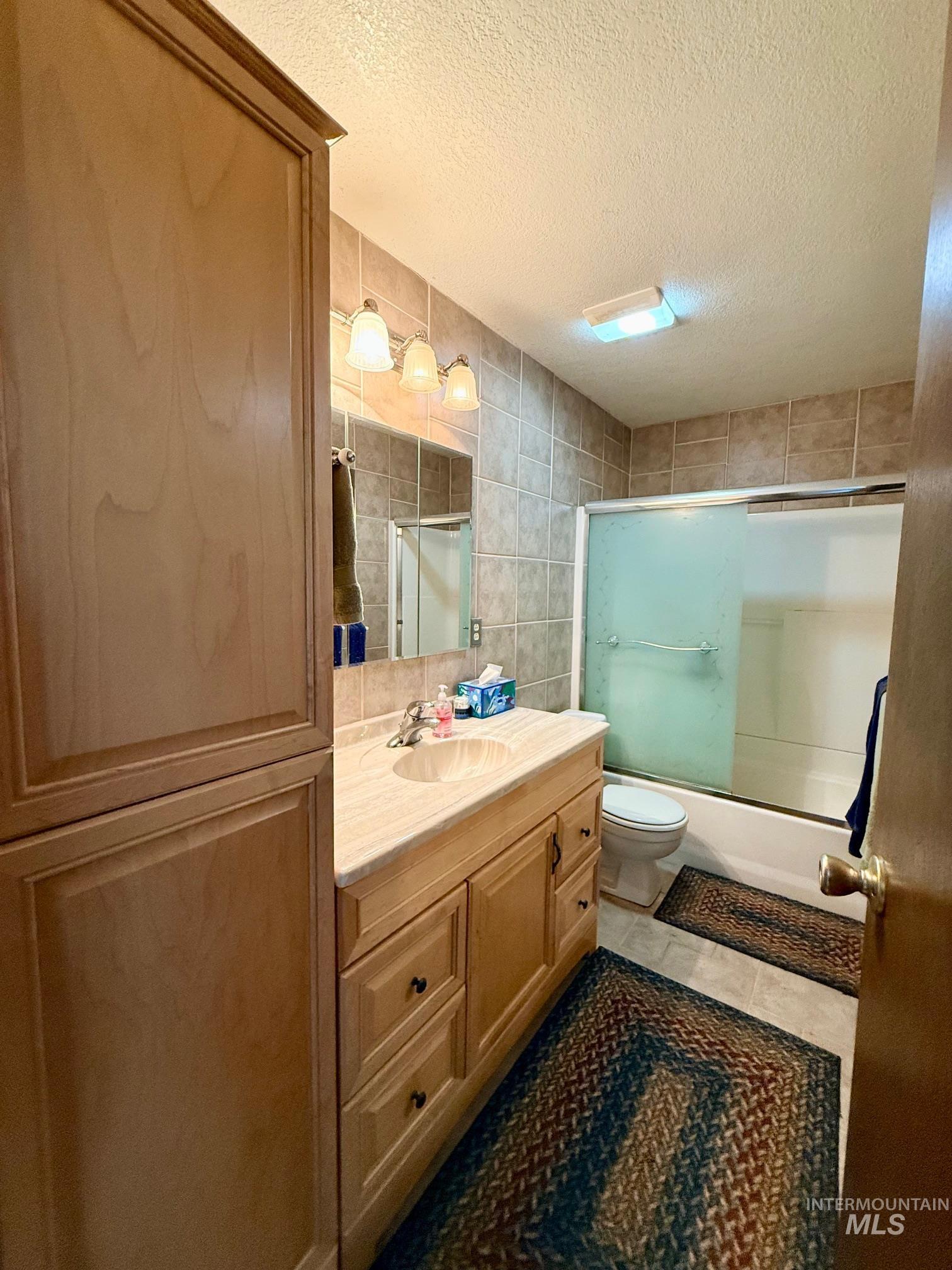 35322 River Road Lenore, ID 83541 - Photo 23 of 42 Bathroom featuring a large wood-finish vanity with an integrated sink and light-colored countertop