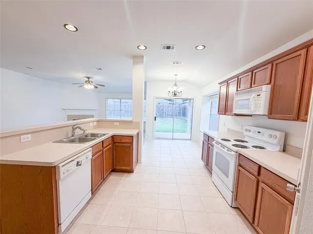 a large kitchen with a stove top oven sink and cabinets