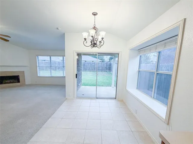 a view of an empty room with a fireplace and a window