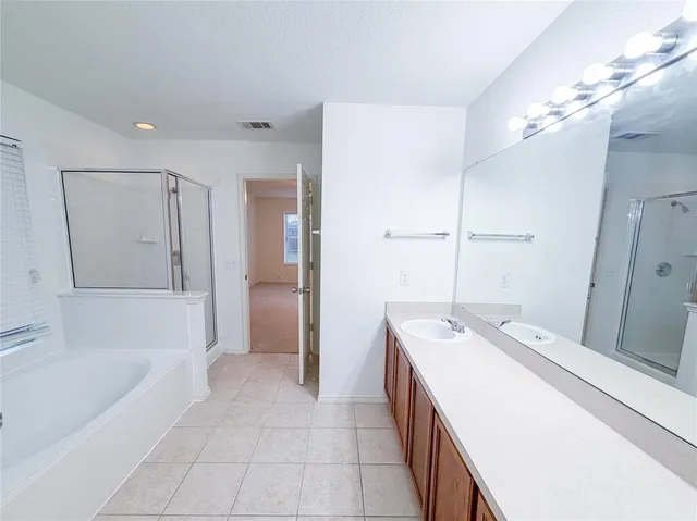 a spacious bathroom with a tub sink and mirror