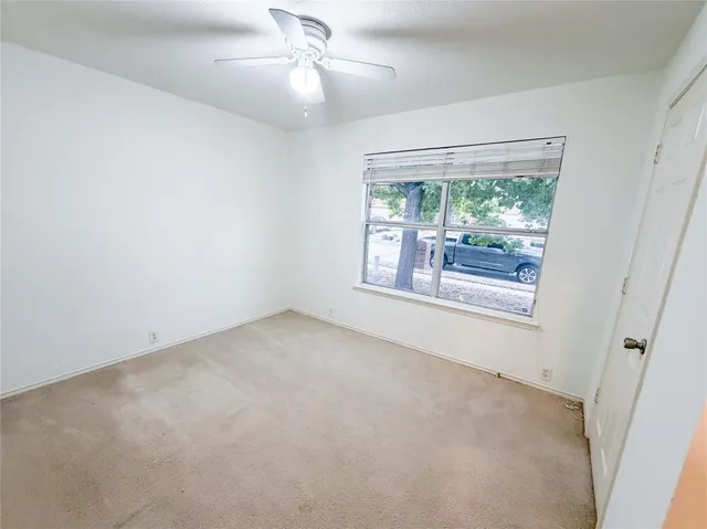 en empty room with windows and ceiling fan
