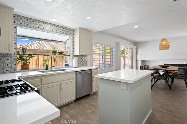 a kitchen with granite countertop a sink cabinets and wooden floor