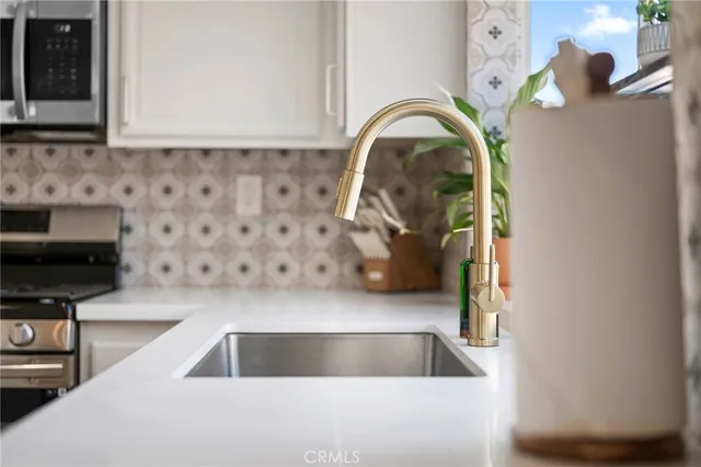 a kitchen with stainless steel appliances white cabinets and a sink