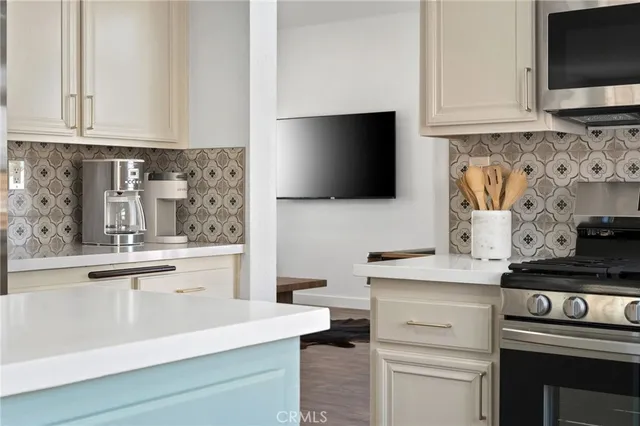 a kitchen with stainless steel appliances granite countertop white cabinets and black stove top oven with granite countertops