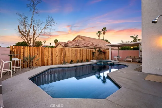 a view of a roof deck with couches and wooden fence