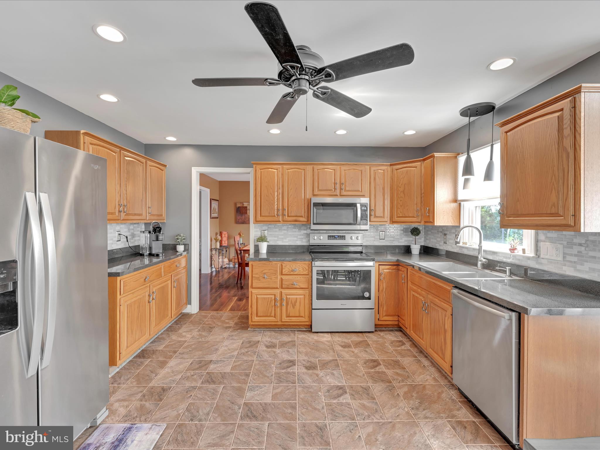 27 Flint Ridge Drive Reading, PA 19607 - Photo 8 of 31 a kitchen with stainless steel appliances granite countertop a refrigerator a sink dishwasher a stove oven and a dining table with wooden floor