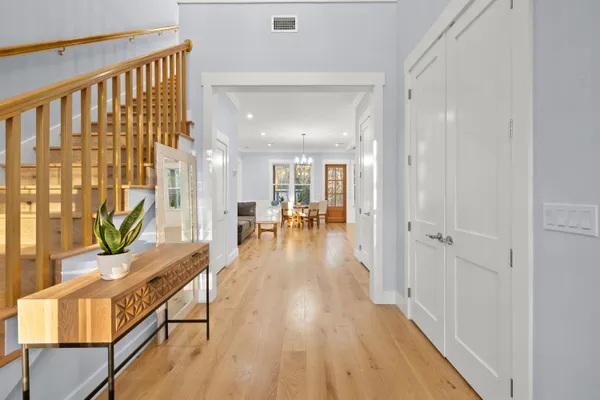 a view of a hallway with wooden floor and furniture