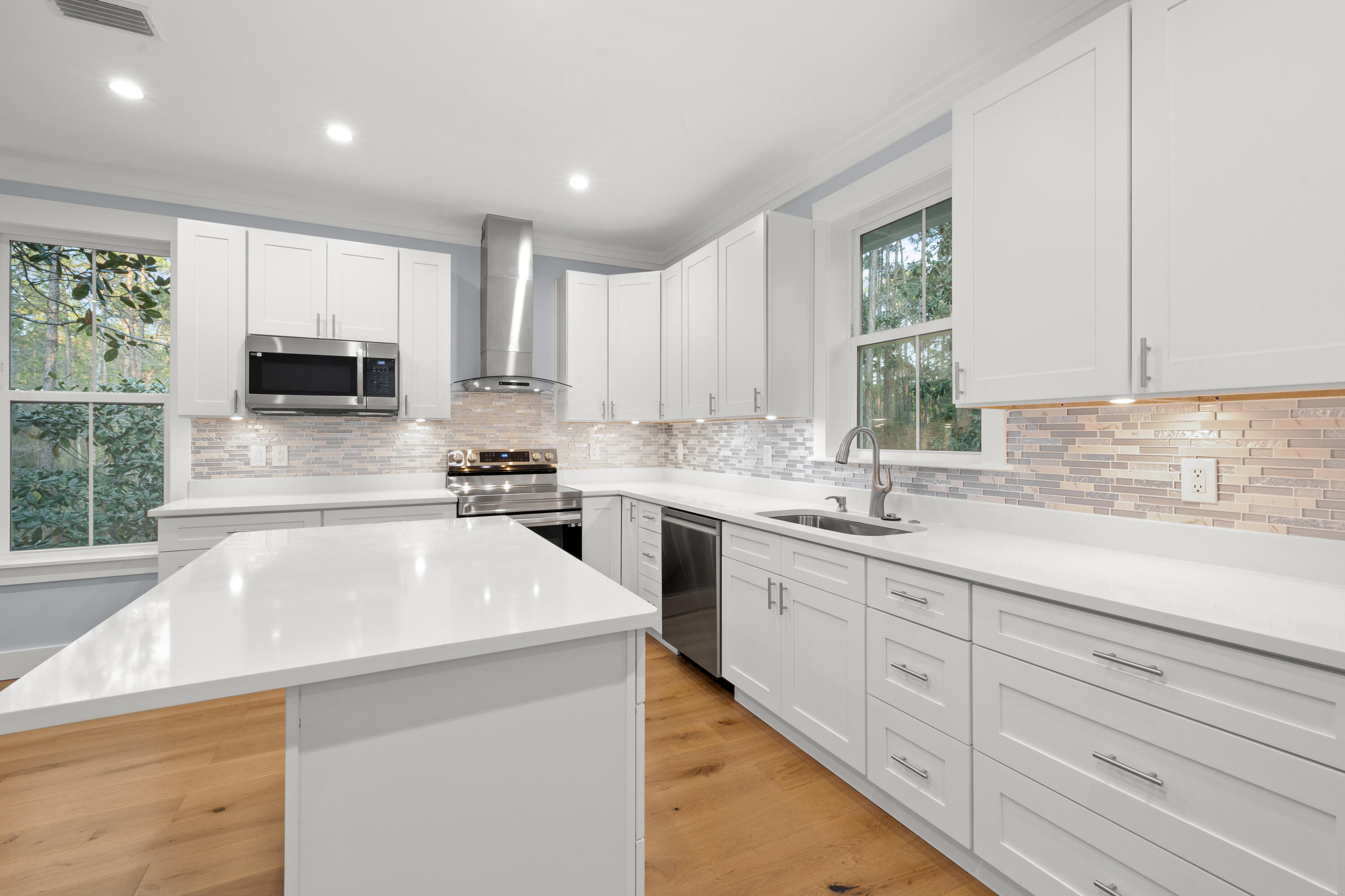 1272 Indian Woman Road Santa Rosa Beach, FL 32459 - Photo 7 of 24 a kitchen with granite countertop white cabinets sink and stainless steel appliances