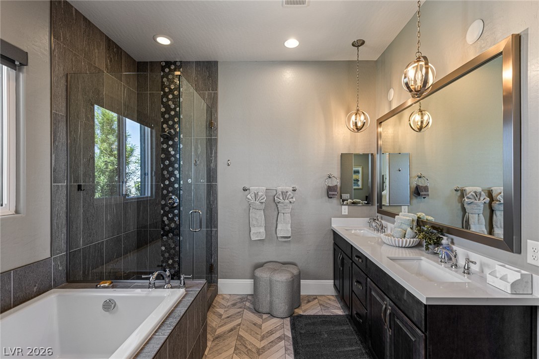 10118 Copper Edge Road Las Vegas, NV 89148 - Photo 19 of 48 Indulge in a tranquil retreat featuring a spacious soaking tub and a sleek dual-vanity setup.