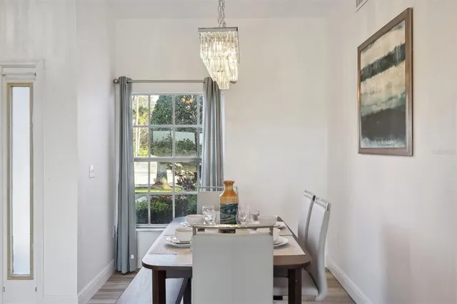 a dining room with furniture a chandelier and wooden floor