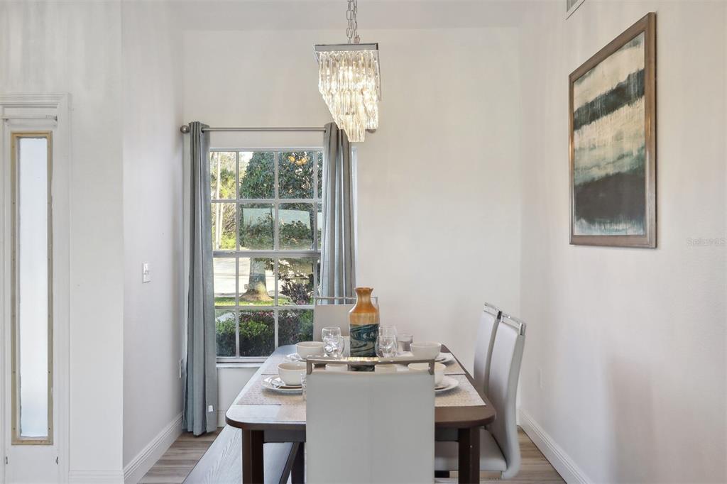 312 Eagle Ridge Drive, Unit 312 Davenport, FL 33837 - Photo 13 of 39 a dining room with furniture a chandelier and wooden floor