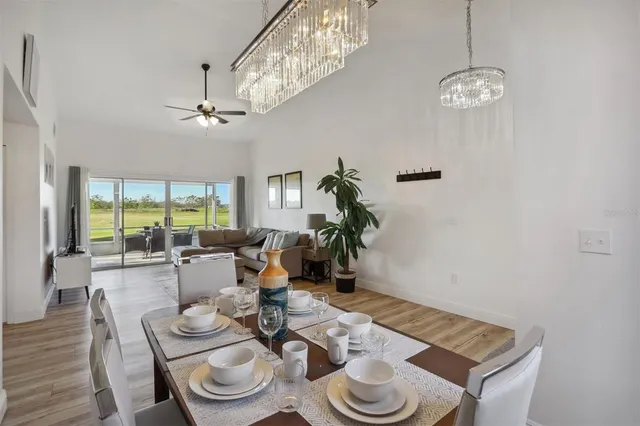 a view of a dining room with furniture a chandelier and wooden floor