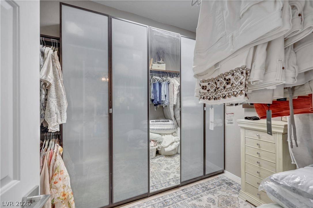 2635 Dirleton Place Henderson, NV 89044 - Photo 30 of 50 A spacious walk-in closet boasts custom frosted glass doors and built-in storage solutions.