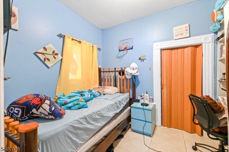 183 Walnut Street Paterson, NJ 07522 - Photo 12 of 37 a bedroom with a bed and a table