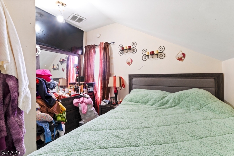 183 Walnut Street Paterson, NJ 07522 - Photo 13 of 37 a bedroom with a bed and a view of walk in closet