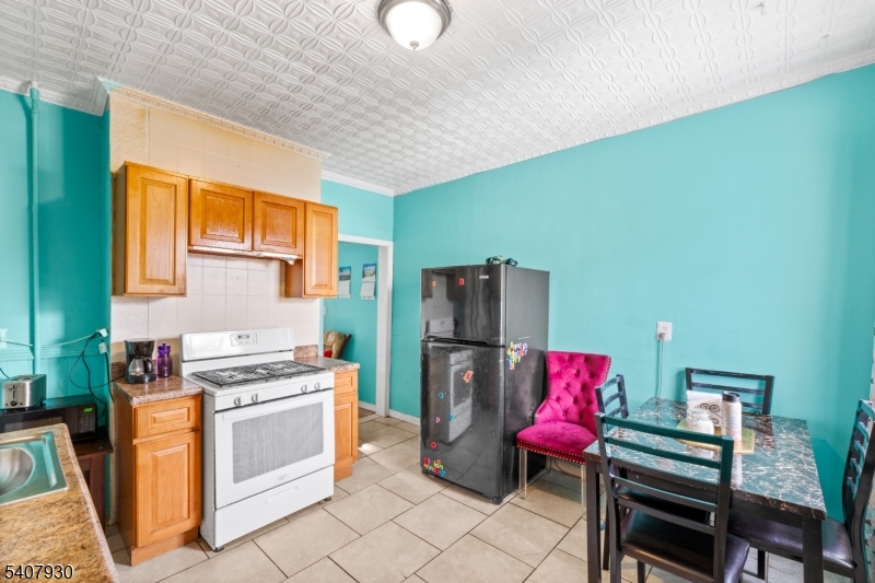 183 Walnut Street Paterson, NJ 07522 - Photo 24 of 37 a kitchen with furniture and a refrigerator