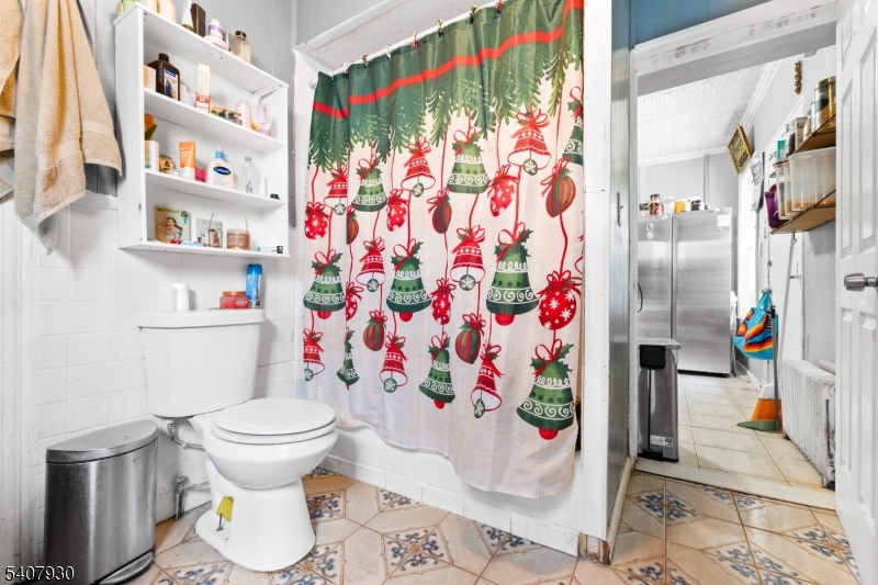 183 Walnut Street Paterson, NJ 07522 - Photo 33 of 37 a bathroom with a toilet and a shower curtain