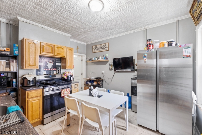 183 Walnut Street Paterson, NJ 07522 - Photo 36 of 37 a kitchen with stainless steel appliances granite countertop a stove a refrigerator a sink a dining table and chairs with wooden floor