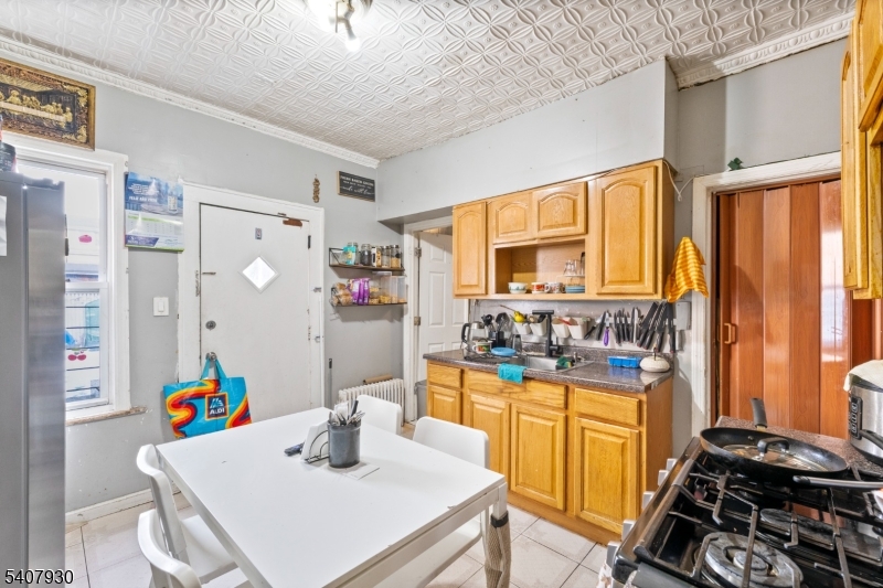 183 Walnut Street Paterson, NJ 07522 - Photo 37 of 37 a kitchen with a stove a refrigerator and a dining table