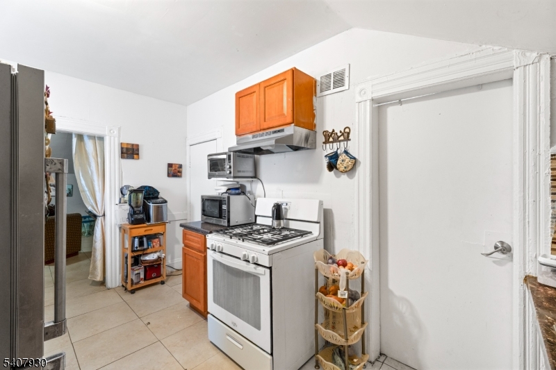 183 Walnut Street Paterson, NJ 07522 - Photo 10 of 37 a kitchen with stainless steel appliances granite countertop a refrigerator and a stove top oven