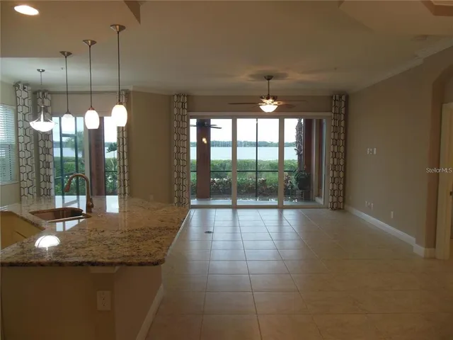 a open kitchen with granite countertop a sink and a large window