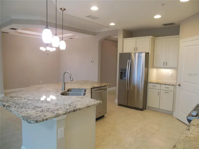 a kitchen with stainless steel appliances granite countertop a refrigerator and a sink