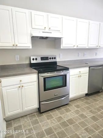 a stove top oven sitting inside of a kitchen