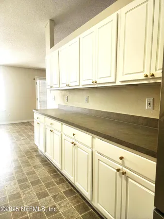 a kitchen with stainless steel appliances granite countertop a sink and a white cabinets